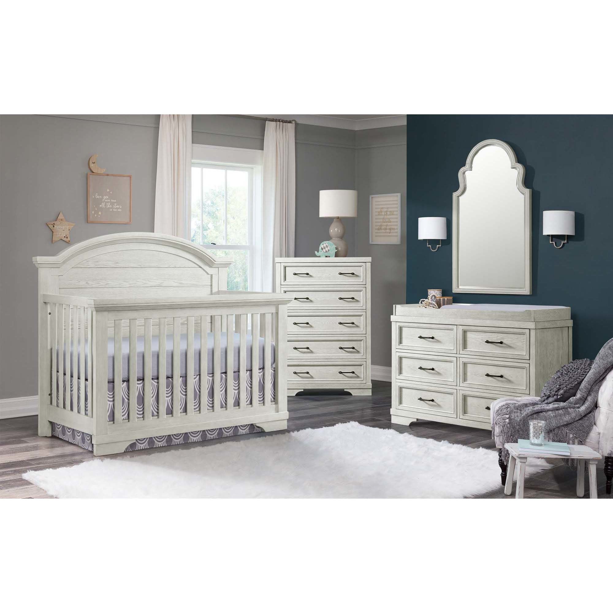 White distressed kids bedroom set: crib/bed with arched headboard, matching dresser and mirror, soft rug and window light